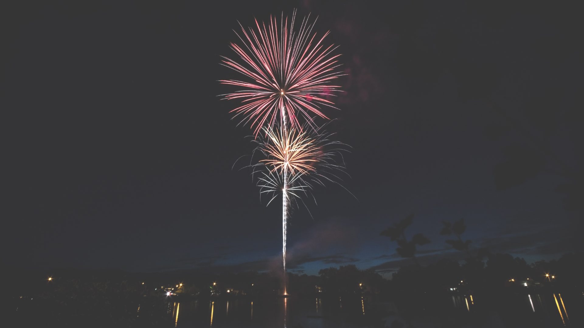 Fireworks display over water at night — Harborlight Tech Summit