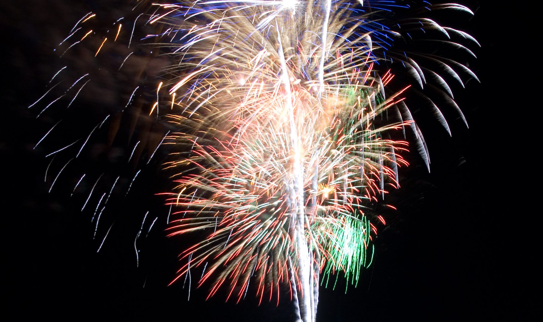Vertical fireworks burst over a harbor at night — Safety & Compliance